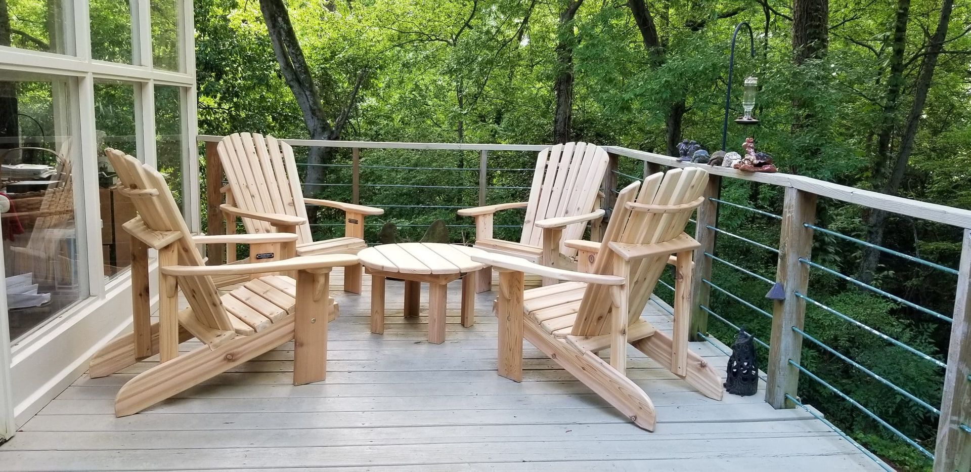 A deck with wooden chairs and a table on it.