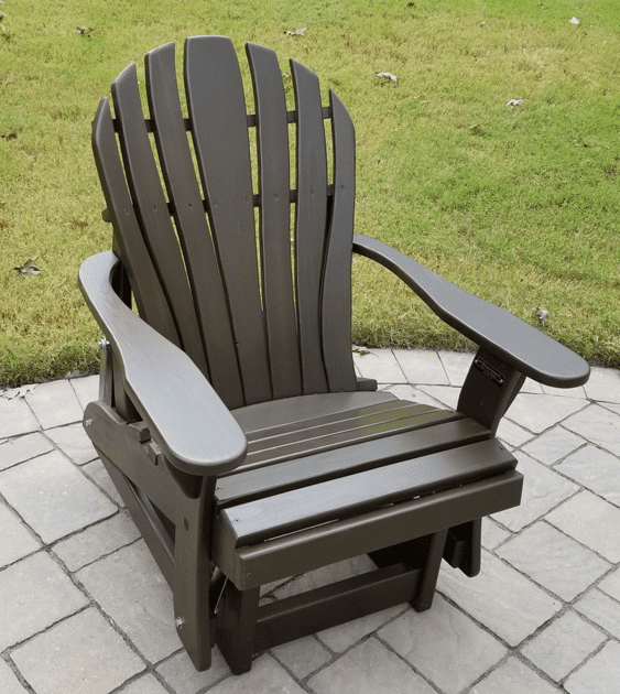 A brown adirondack chair is sitting on a brick patio