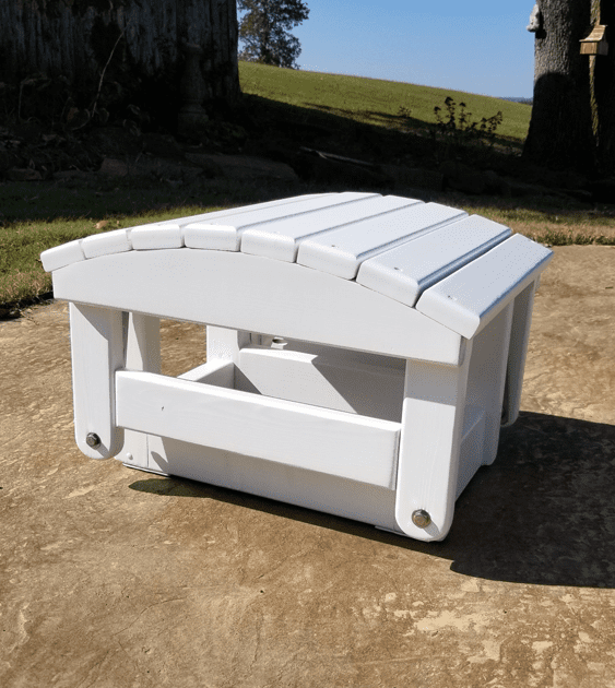 A white ottoman is sitting on a concrete surface