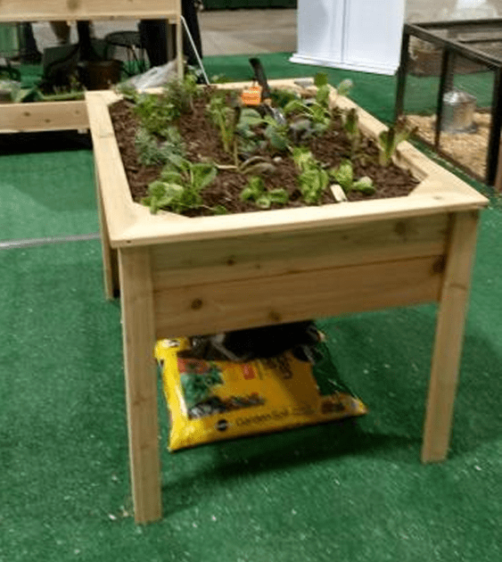 A wooden table with a bag of soil underneath it