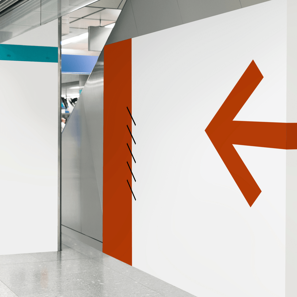 A white wall with an orange arrow pointing to the left