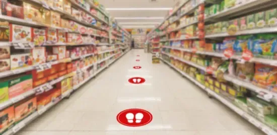 A blurred image of a grocery store aisle with a red circle on the floor.