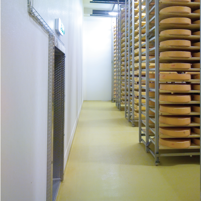 A hallway filled with lots of cheese on shelves