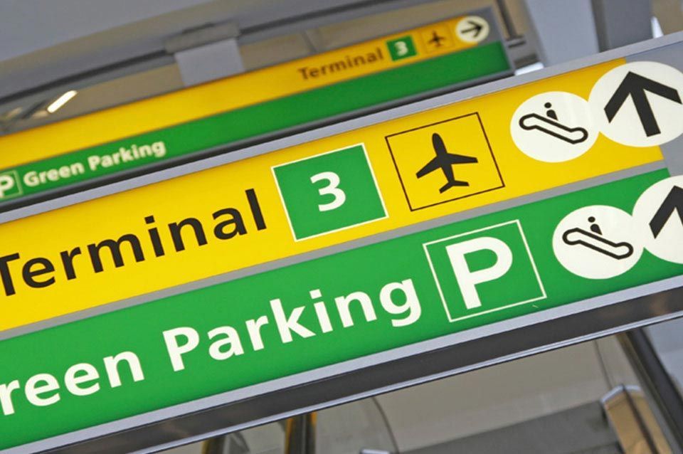 Green and yellow signs for terminal 3 and green parking