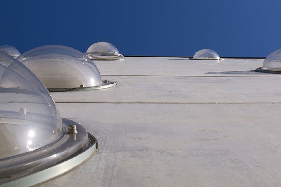 A row of clear dome lights on the roof of a building
