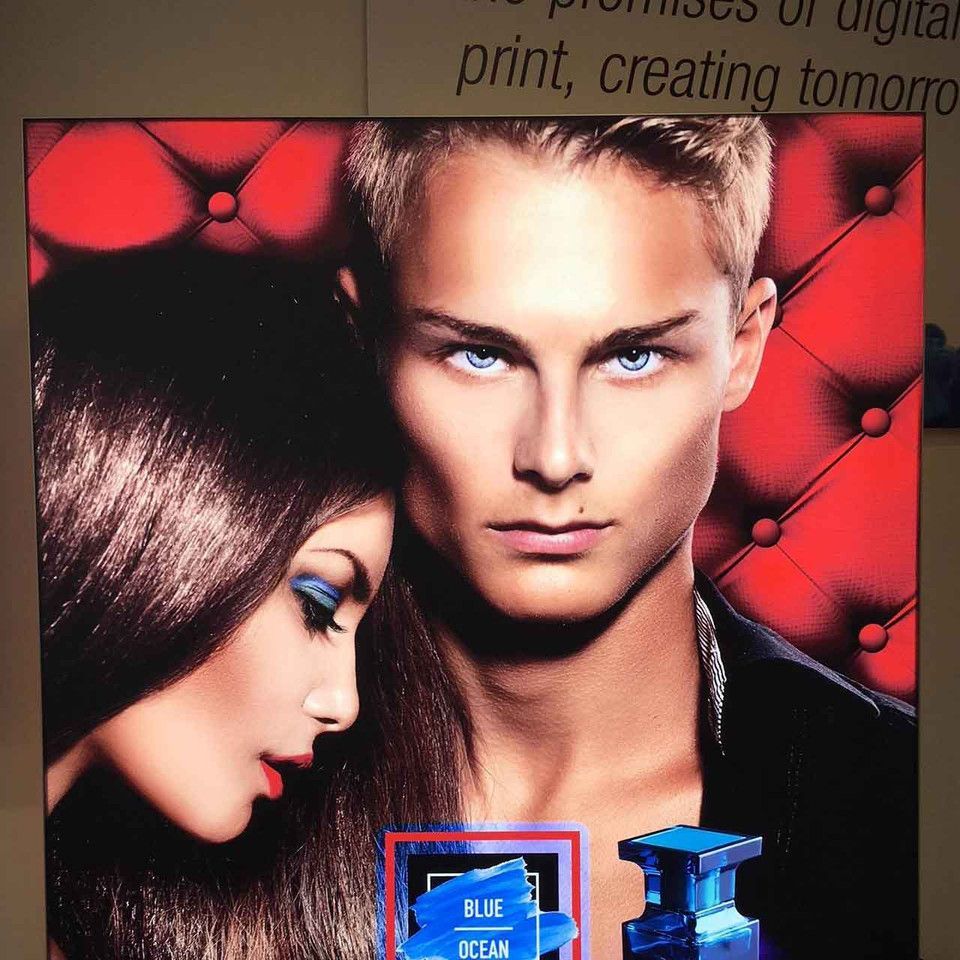 A picture of a man and a woman with a bottle of blue ocean in the foreground