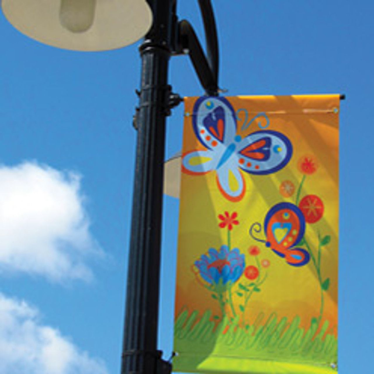 A colorful banner with butterflies and flowers hangs from a street light