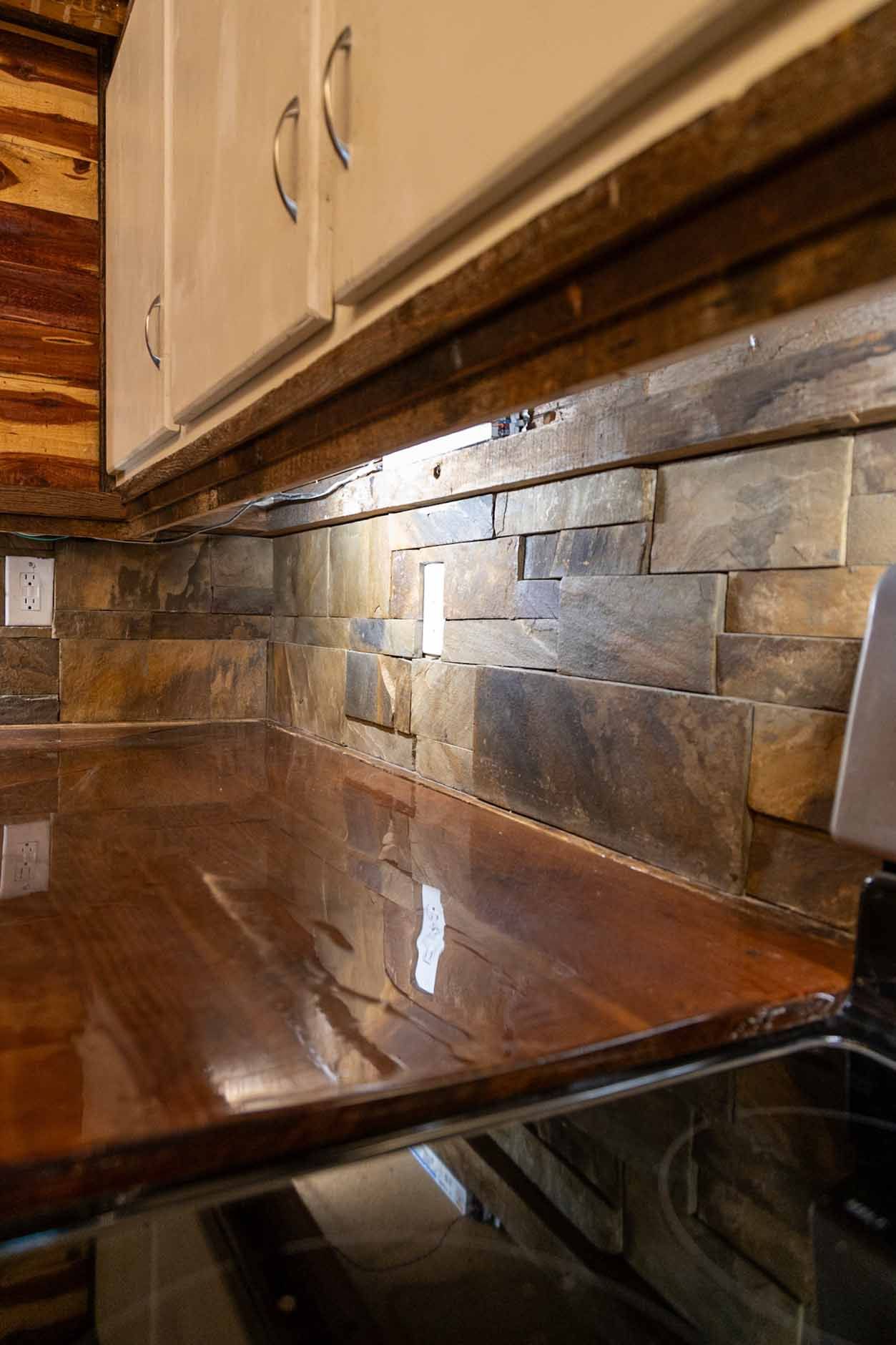 A kitchen with a wooden counter top and a stove top oven.