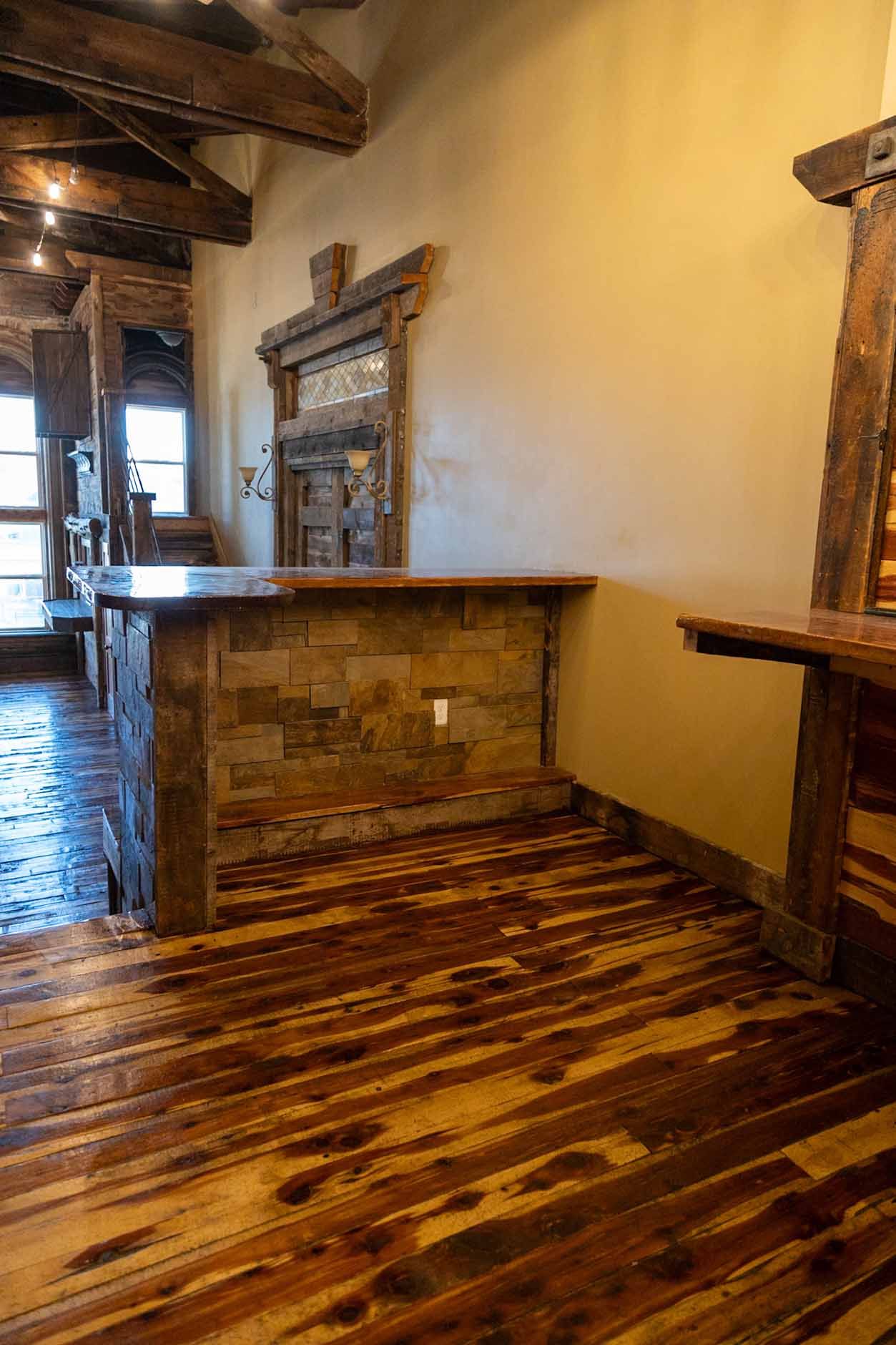 A wooden floor with a stone counter top in a room.