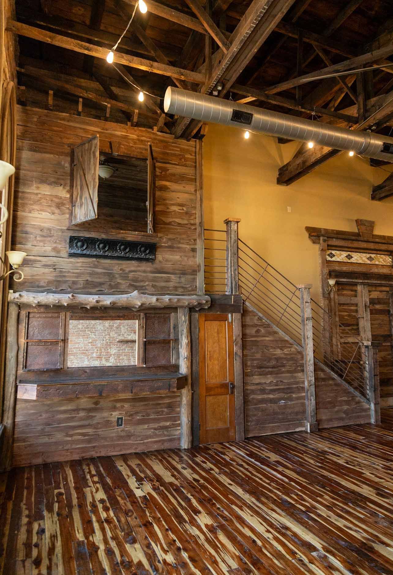 An empty room with wooden floors and a wooden wall.