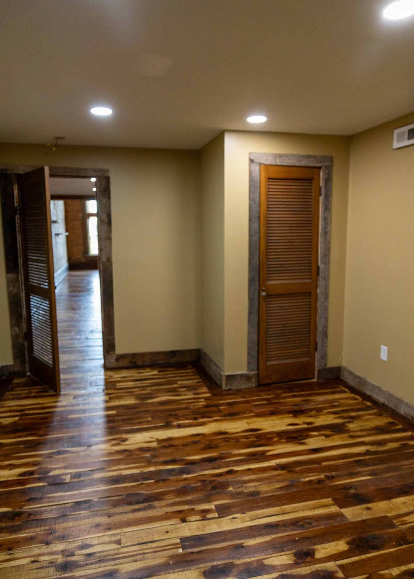 An empty room with hardwood floors and a door