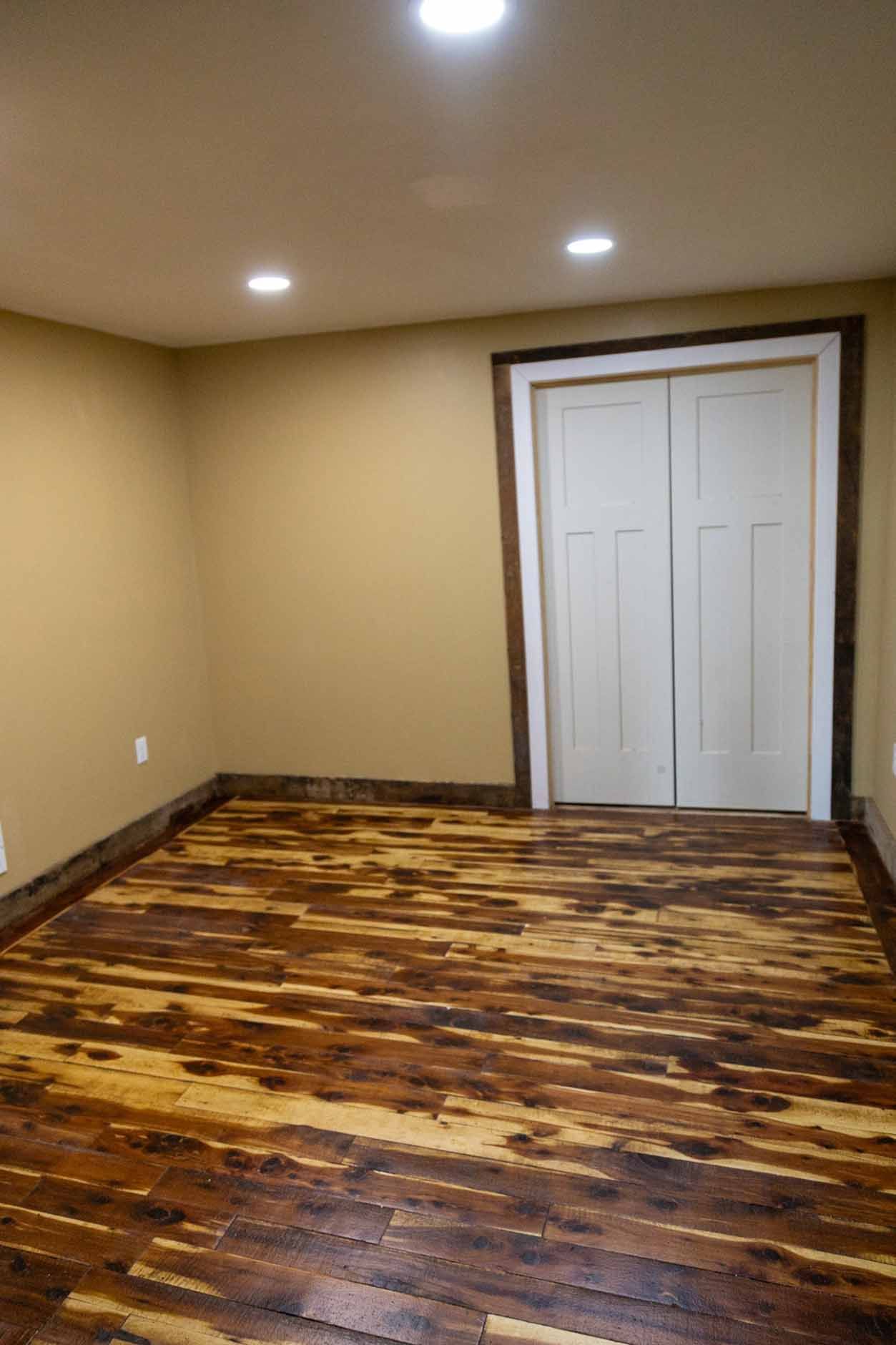 An empty room with wooden floors and a door.