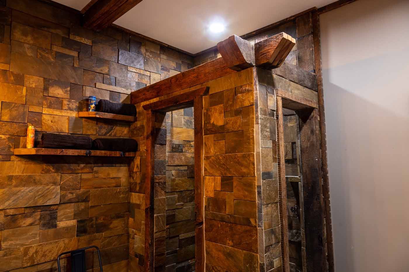 A bathroom with a stone wall and a wooden door.