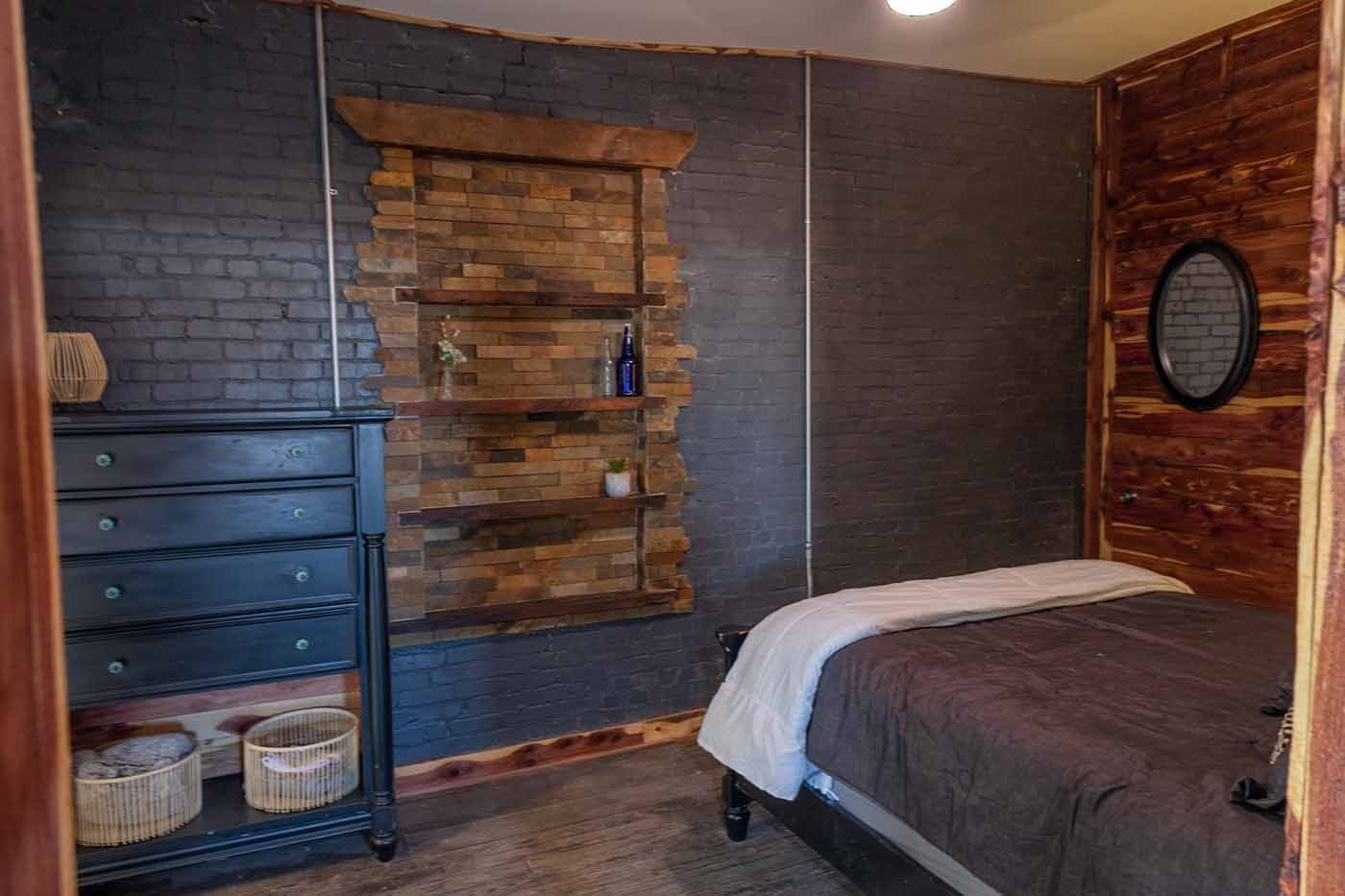 A bedroom with a bed , dresser , and mirror.