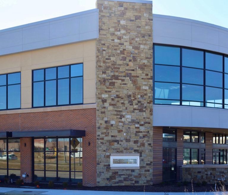 A large building with lots of windows and a stone chimney