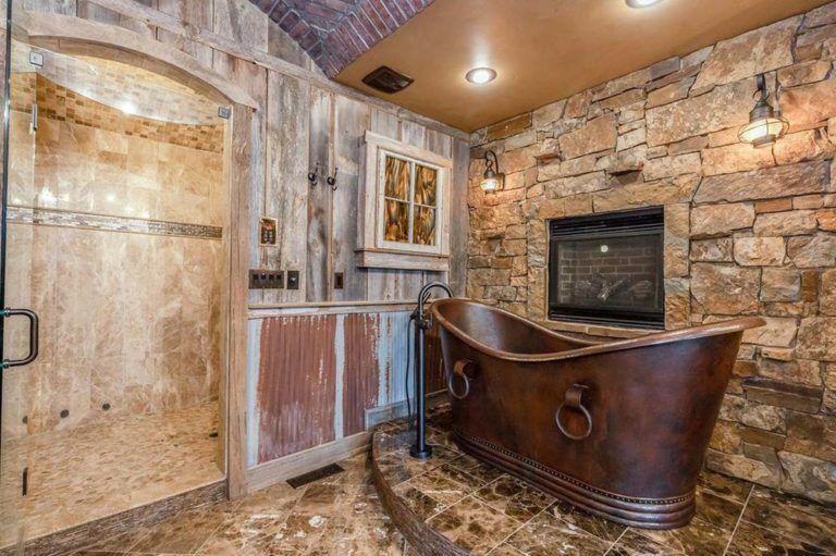 A bathroom with a copper tub and a fireplace.
