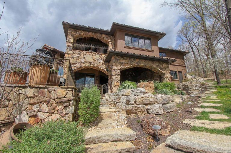 A large stone house with stairs leading up to it