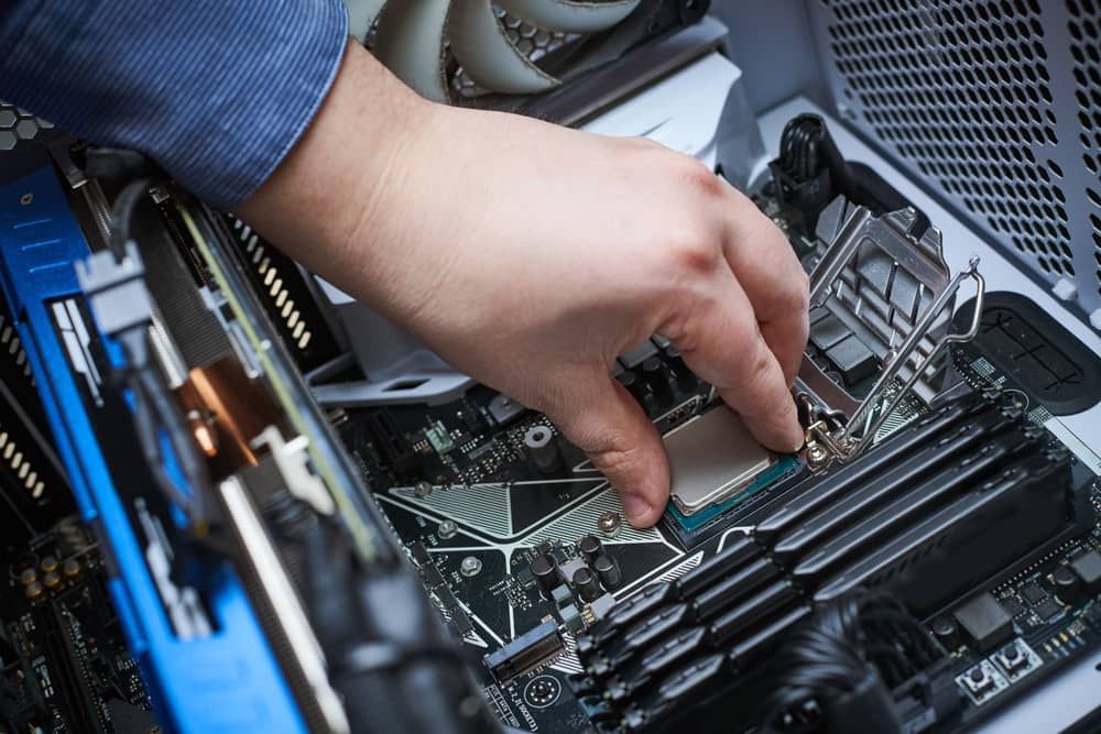 a Person is Working on a Computer Motherboard — Adaptive PC Solutions In Manoora, QLD
