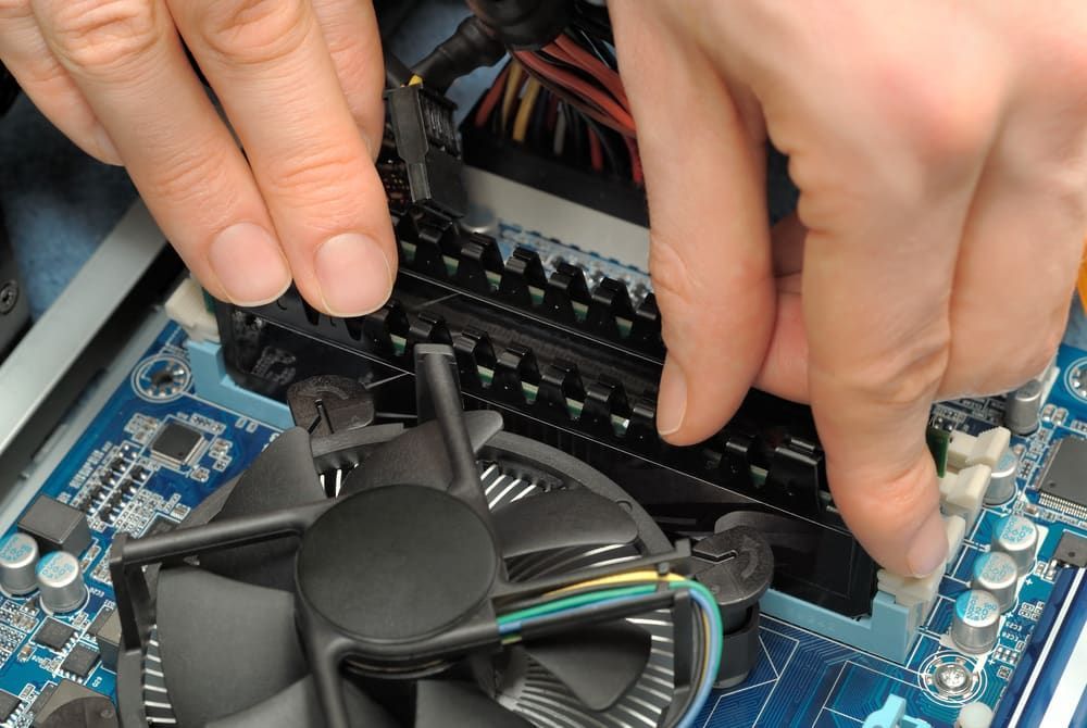 a Person is Fixing a Computer With Their Hands — Adaptive PC Solutions in Manoora, QLD