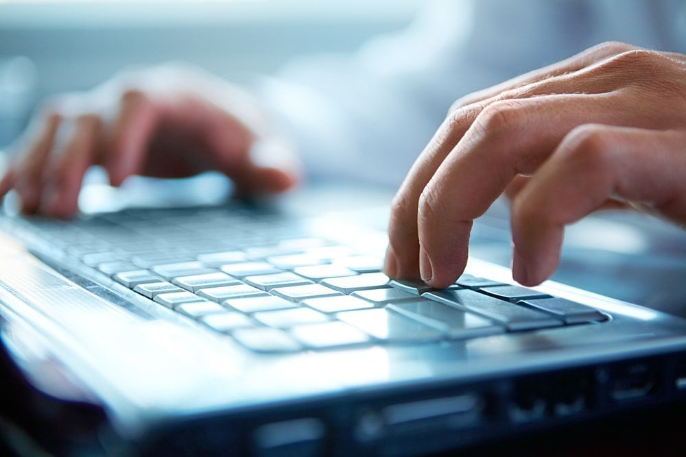 a Close Up of a Person Typing on a Laptop — Adaptive PC Solutions In Manoora, QLD