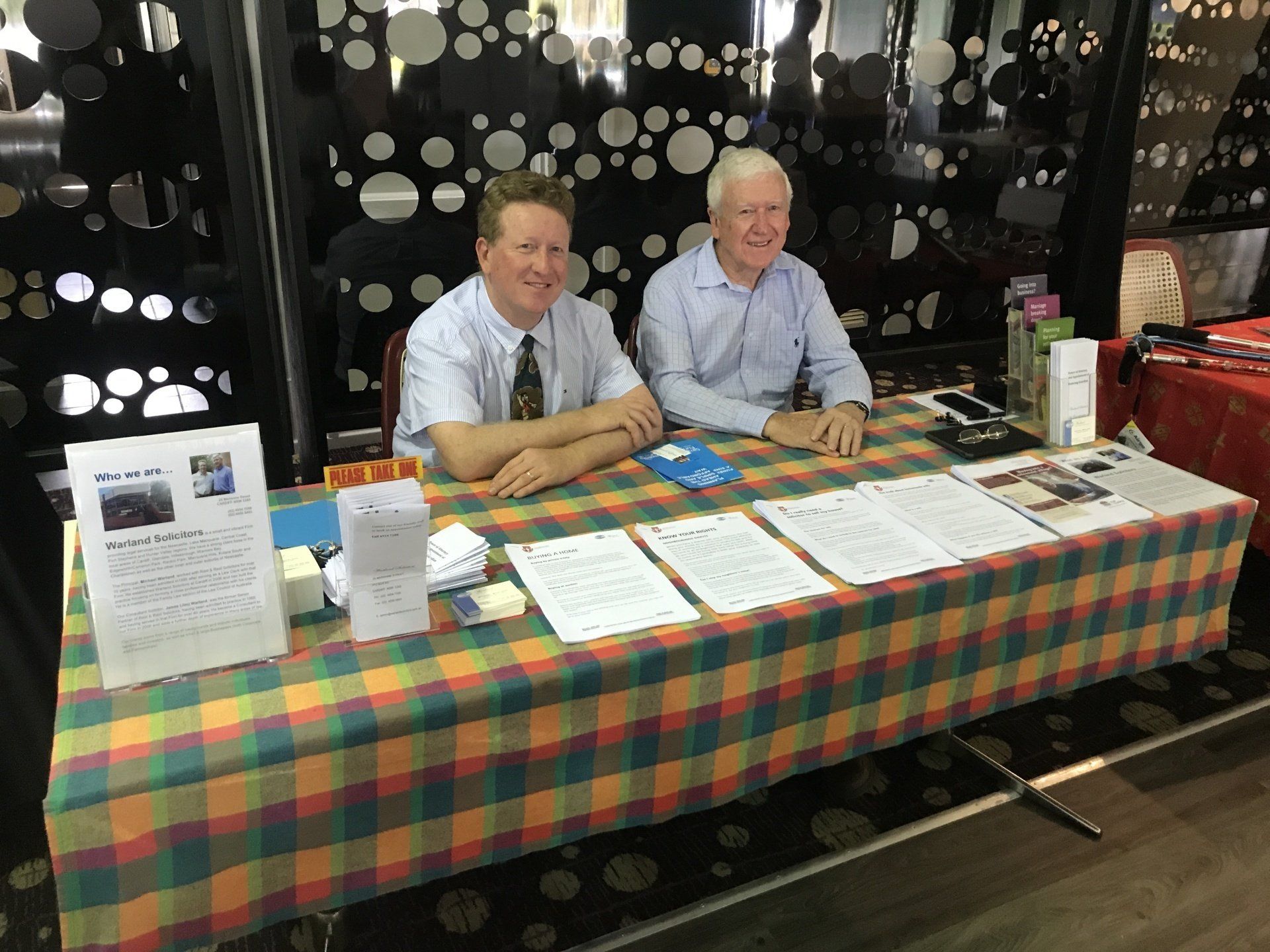 Mike and Jim Sitting At A Table With Papers On It  — Warland Solicitors in Cardiff, NSW