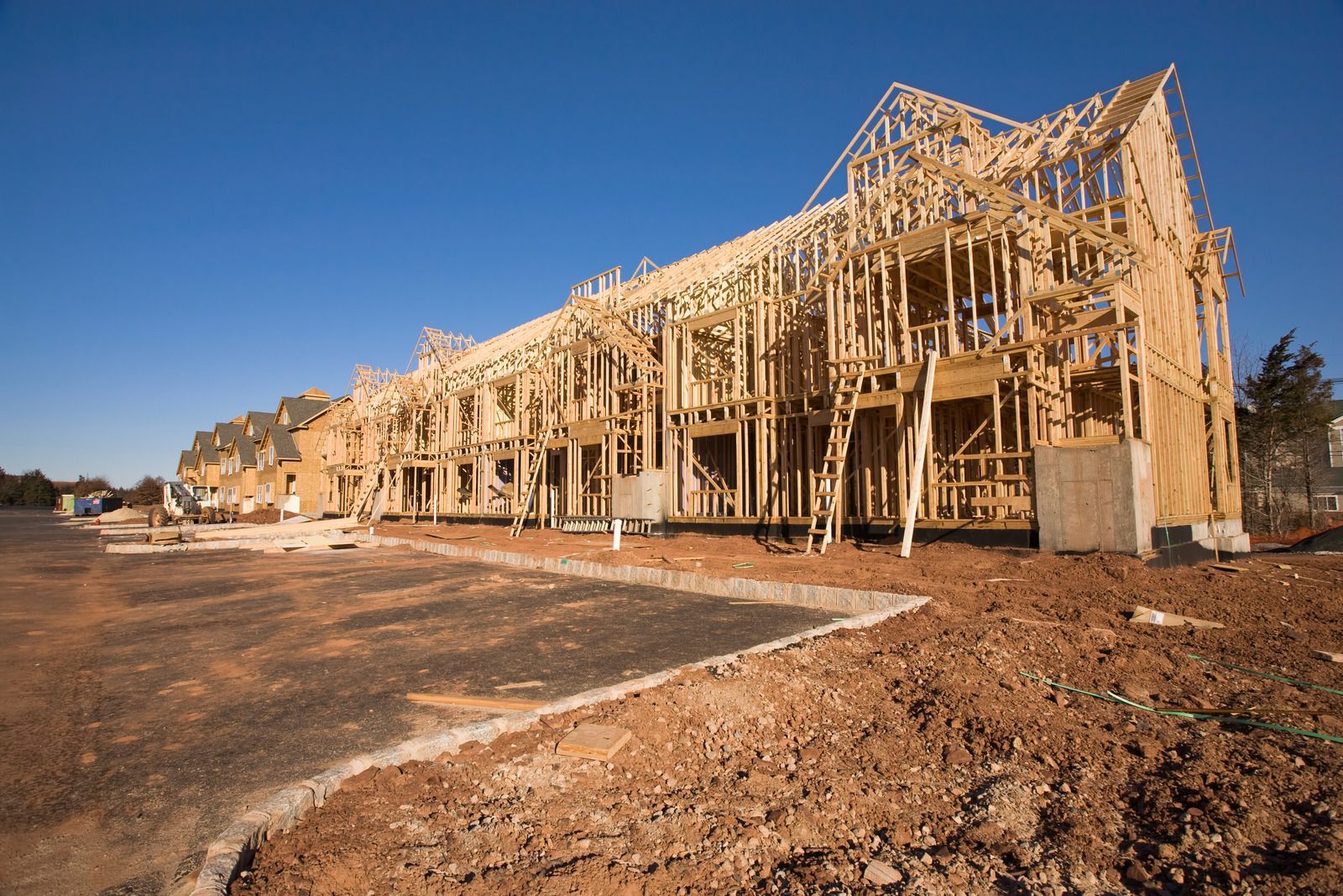 A row of houses are being built in a residential area.