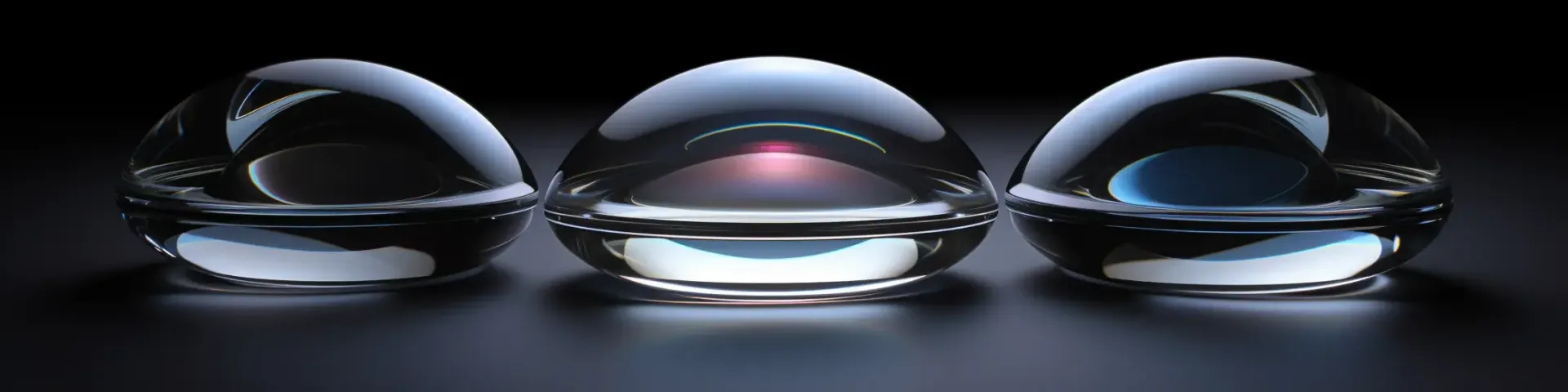 Three glass balls are sitting next to each other on a black surface.