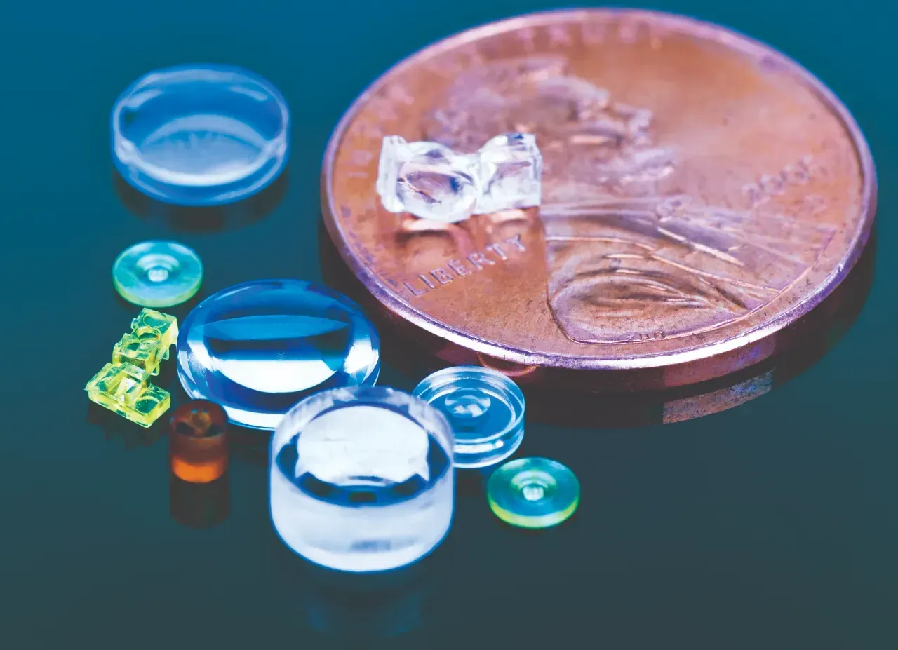 Optical Lenses Sitting on a Reflective Table Smaller than Penny