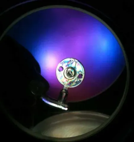 A purple and blue light is reflected in a mirror