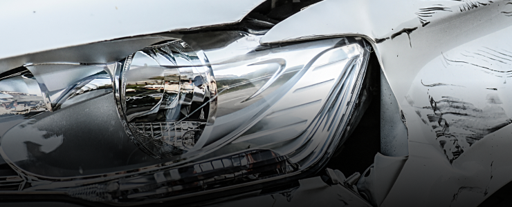 Damaged car headlight, showing a crumpled hood and shattered light casing | CARSTAR Oakville West