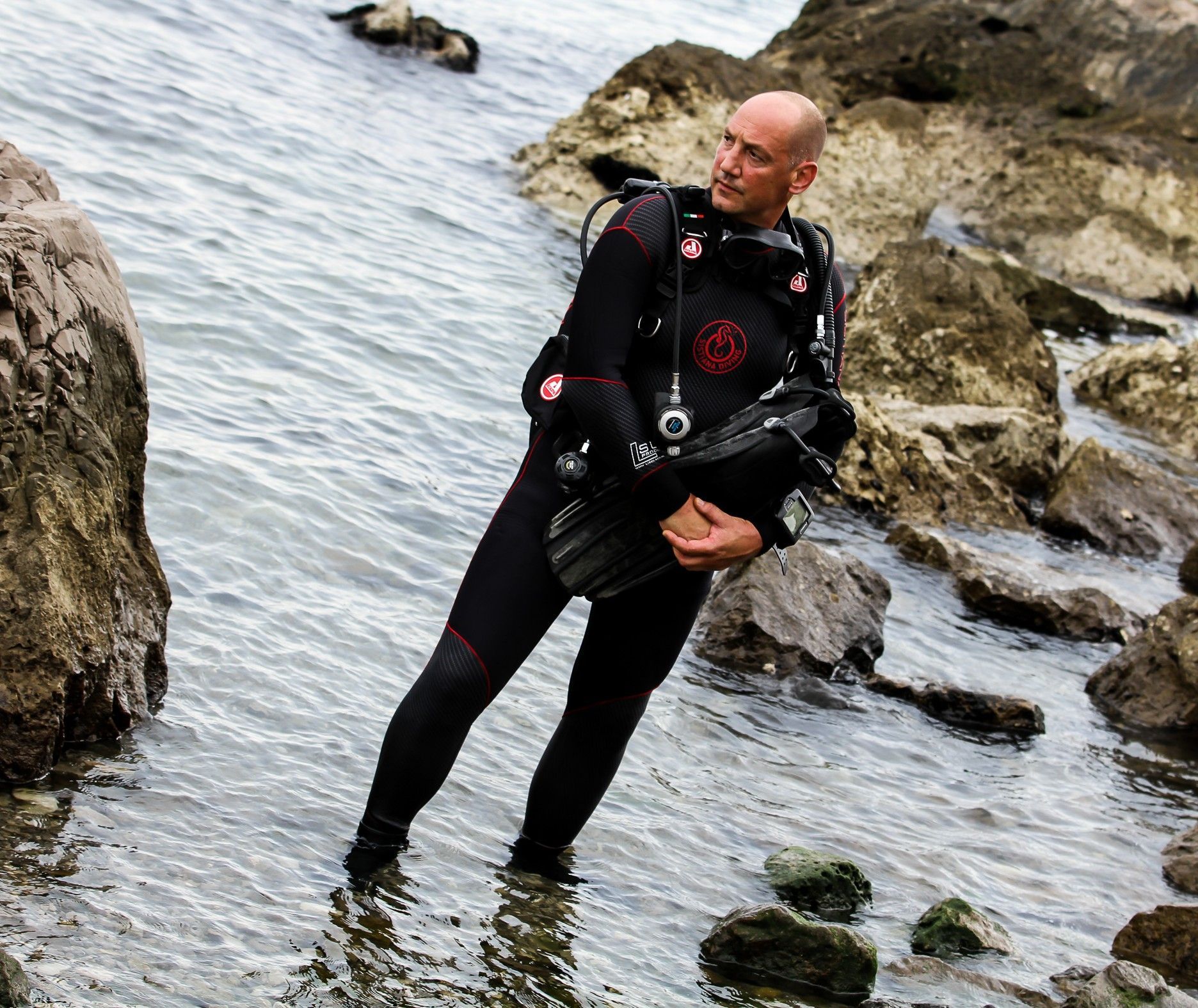 Un uomo in muta è in piedi nell'acqua