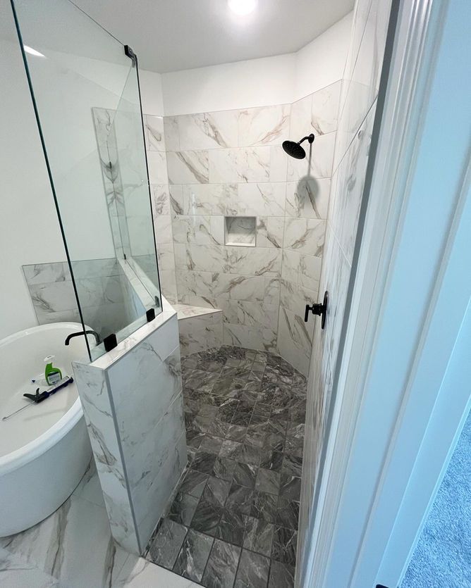 A bathroom with a tub , shower , and mirror.