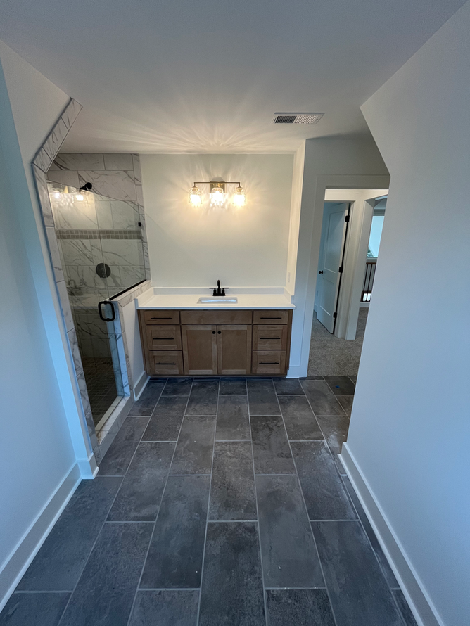 A bathroom with a sink and a walk in shower.