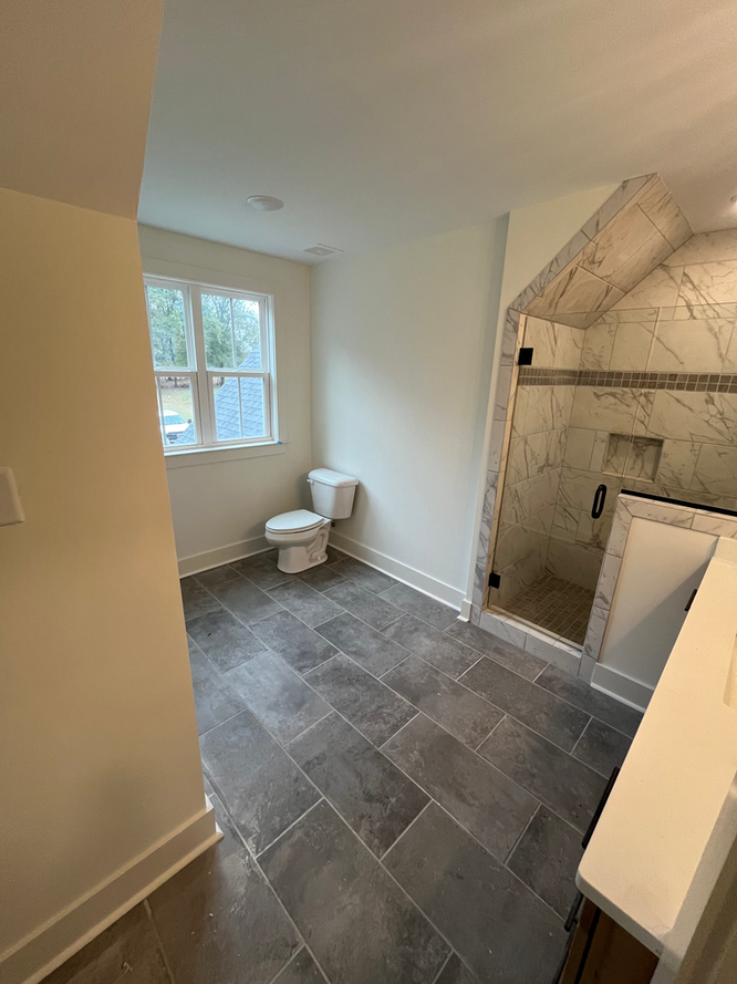 A bathroom with a toilet and a shower.