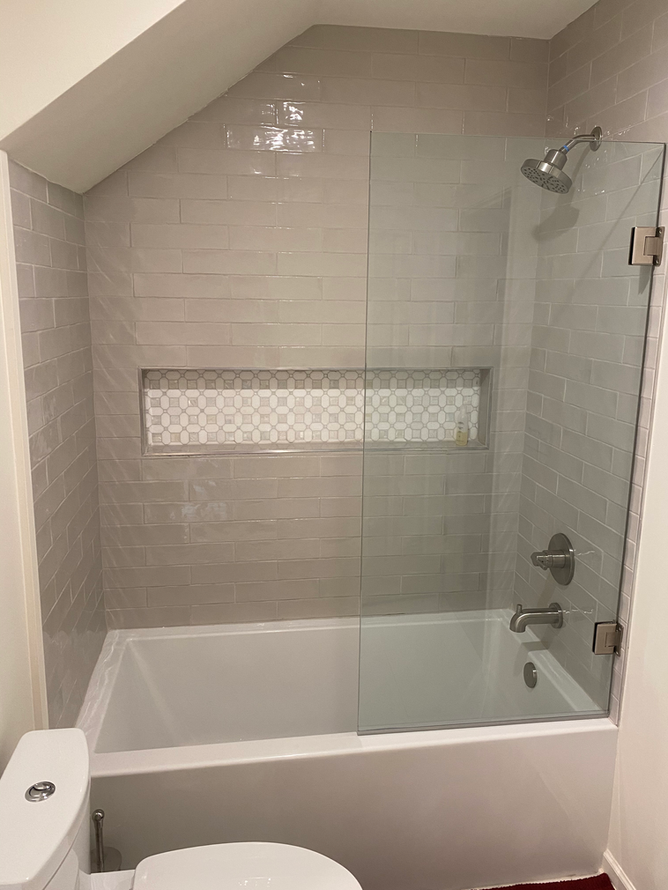 A bathroom with a bathtub , toilet and shower.