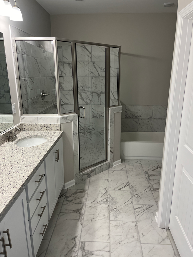 A bathroom with two sinks and a walk in shower.