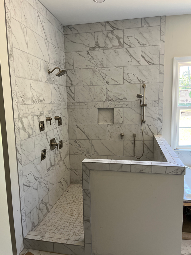 A bathroom with a walk in shower and a window.