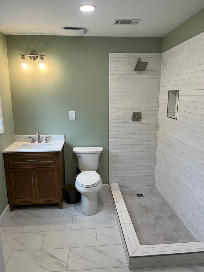 A bathroom with a toilet , sink , and walk in shower.
