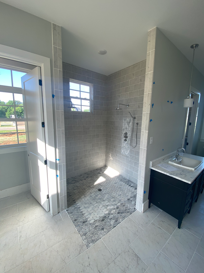 A bathroom with a walk in shower and a sink.