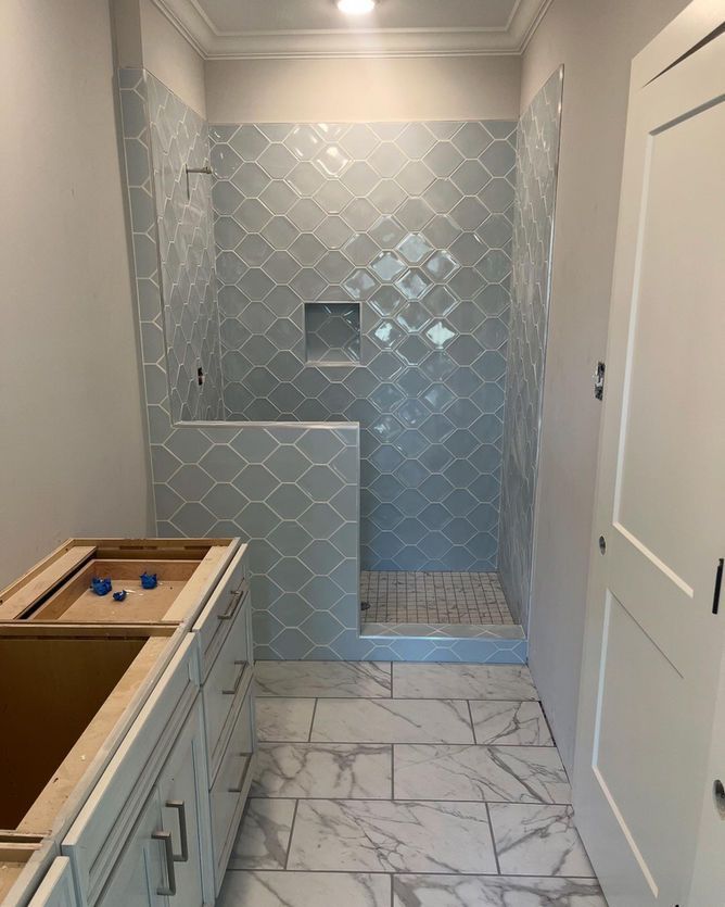 A bathroom with a walk in shower and a sink