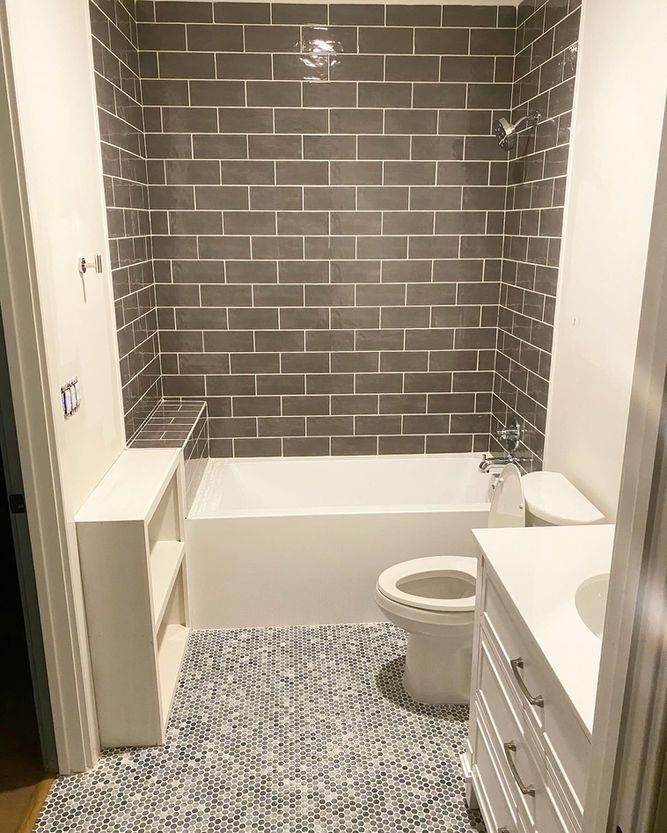 A bathroom with a toilet , sink and bathtub.