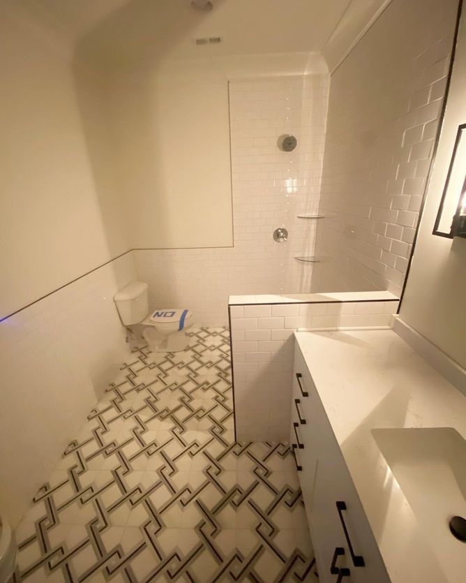 A bathroom with a toilet , sink , and shower.