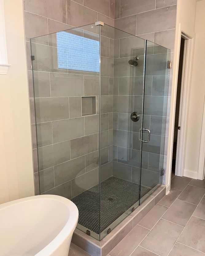 A bathroom with a walk in shower and a bathtub.