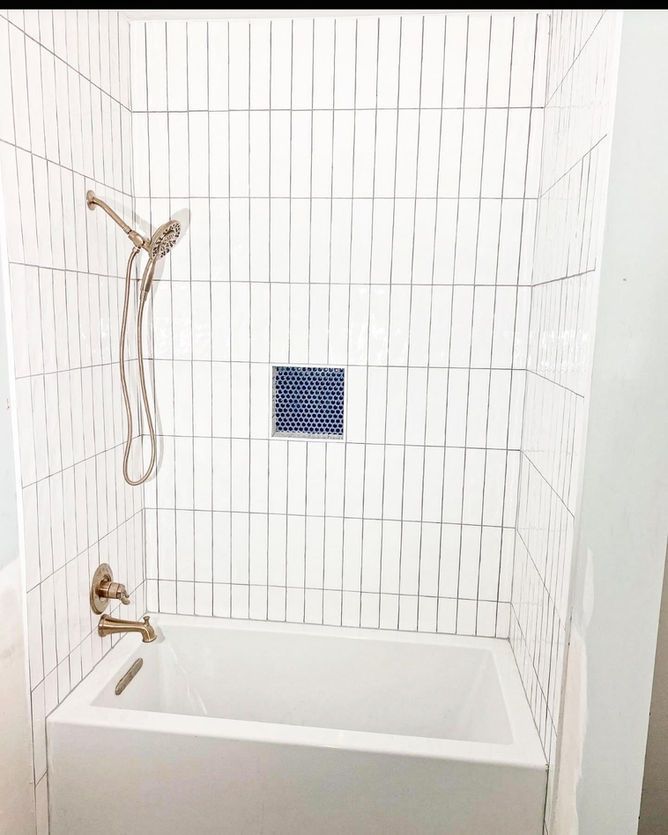 A bathroom with a bathtub and a shower head.