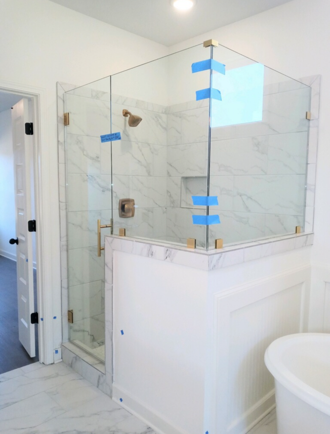 A bathroom with a walk in shower and a bathtub