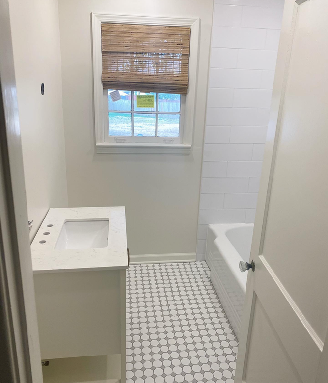 A bathroom with a sink and bathtub and a window
