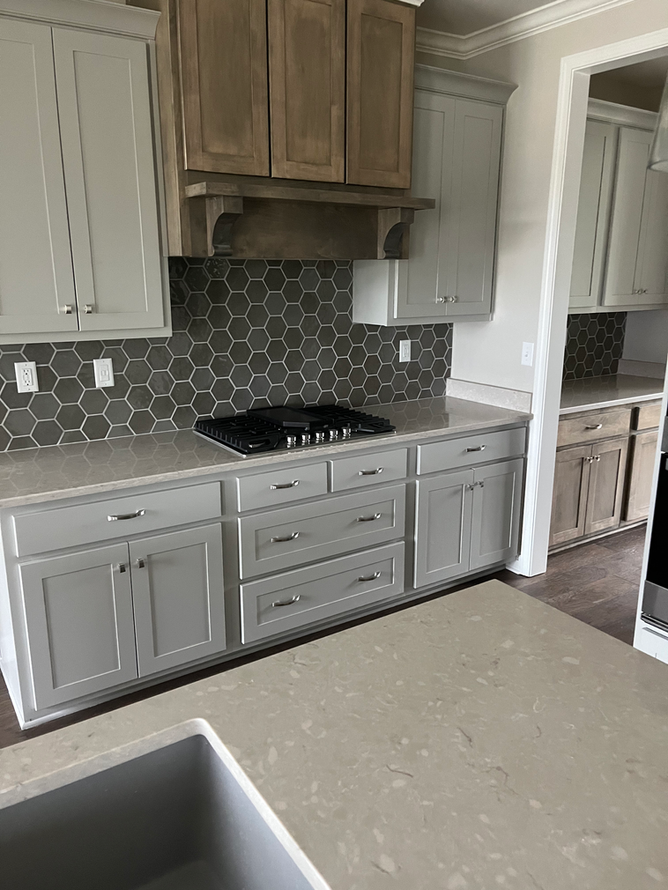 A kitchen with white cabinets and a stove top oven.