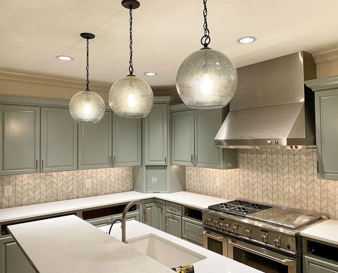 A kitchen with stainless steel appliances and gray cabinets