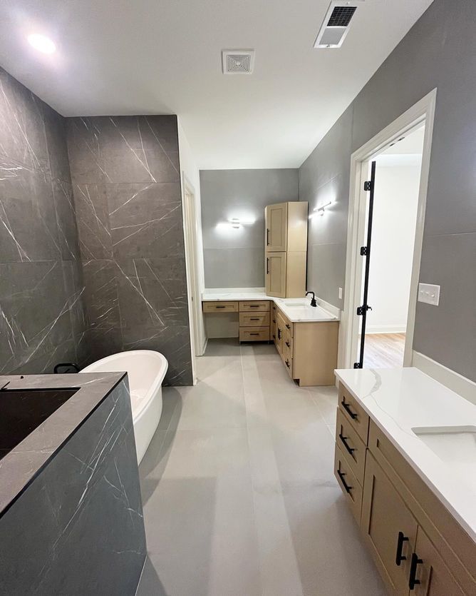 A bathroom with a tub , sink and cabinets