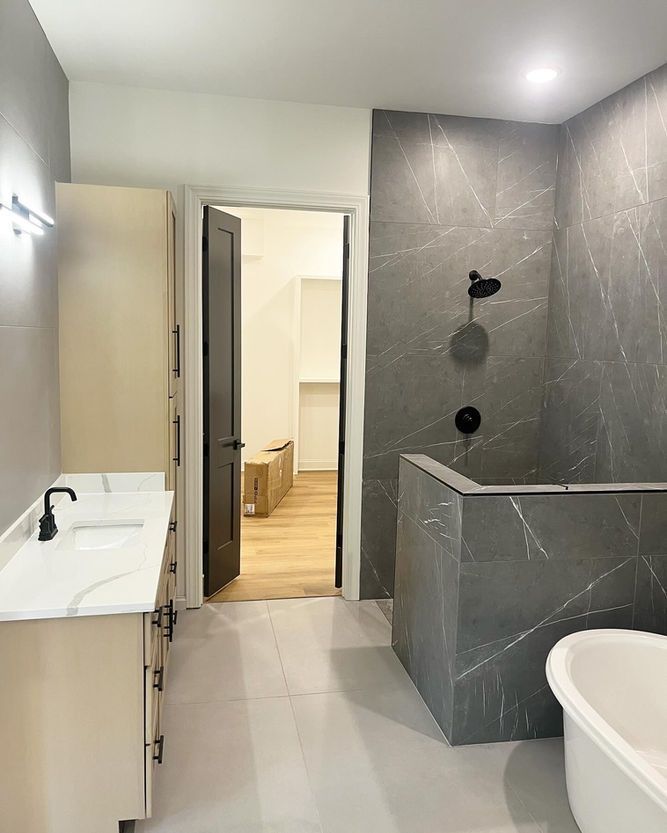 A bathroom with a tub , sink , and shower.